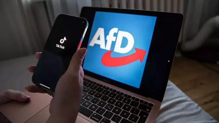 o-persoana-tine-in-mana-un-iphone-care-afiseaza-logo-ul-tiktok-in-timp-ce-pe-un-laptop-poate-fi-vazuta-sigla-afd--e1740293826428