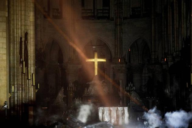 smoke-rises-around-the-altar-in-front-of-the-cross-inside-the-notre-dame-cathedral-as-a-fire-continues-to-burn-in-paris
