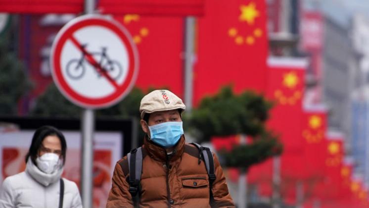 People wear masks at the Nanjing Pedestrian Road, a main shopping area, in Shanghai, China January 24, 2020. REUTERS/Aly Song
