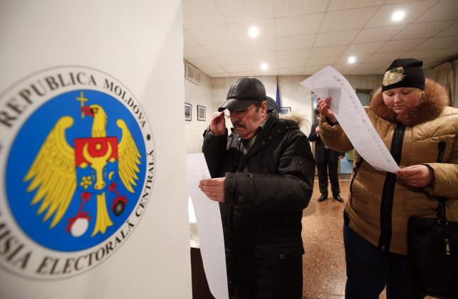 moldovan-citizens-residing-in-russia-read-their-ballots-during-a-parliamentary-election-at-the-moldovan-embassy-in-moscow