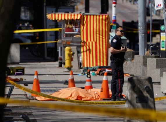 A police officer stands next to a victim of an incident where a van struck multiple people at a major intersection in Toronto's northern suburbs in Toronto, Ontario, Canada, April 23, 2018.   REUTERS/Carlo Allegri