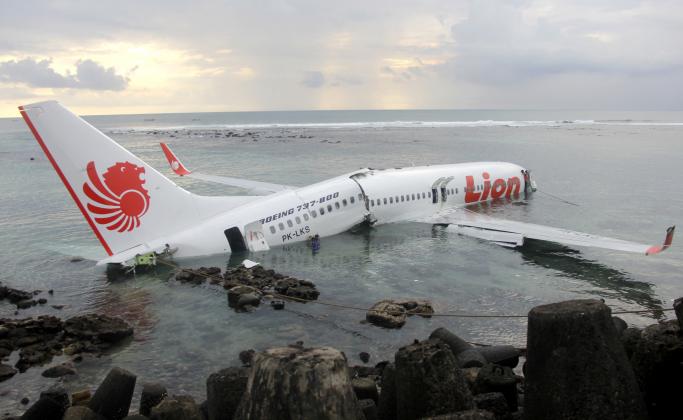 In this photo released by Indonesian Police, the wreckage of a crashed Lion Air plane sits on the water near the airport in Bali, Indonesia on Saturday, April 13, 2013. The plane carrying more than 100 passengers and crew overshot a runway on the Indonesi