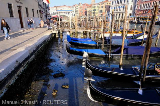 Gondolas are seen in Grand Canal during an exceptionally low tide in the lagoon city of Venice, Italy, February 26, 2021. REUTERS/Manuel Silvestri