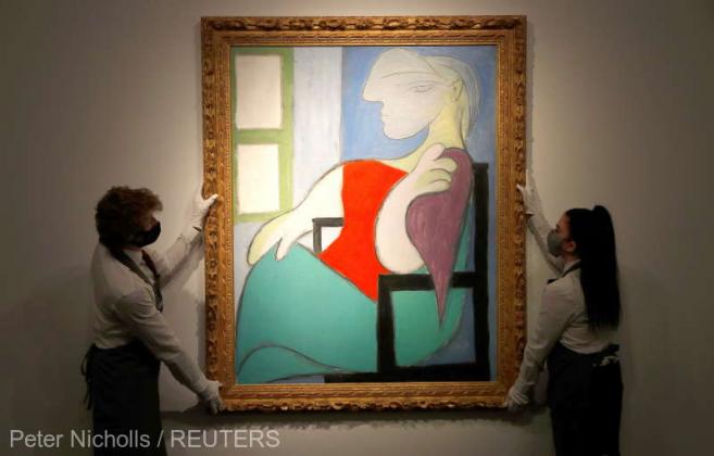 Employees pose for a photograph with "Femme Assise Pres d'Une Fenetre (Marie-Therese)" by Pablo Picasso at Christie's gallery prior to the New York spring season of evening sales, in London, Britain, April 22, 2021. REUTERS/Peter Nicholls NO RESALES. NO