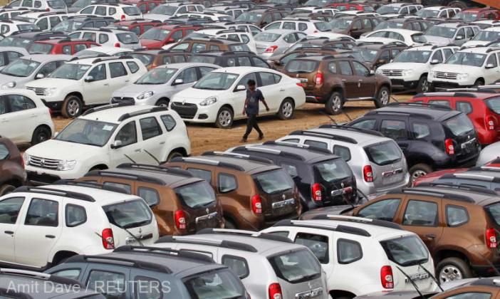 FILE PHOTO: A worker walks past parked Renault cars at its stockyard on the outskirts of the western Indian city of Ahmedabad June 11, 2013. Car sales in India fell an annual 12.3 percent in May, an industry body said on Tuesday, dropping for the seventh