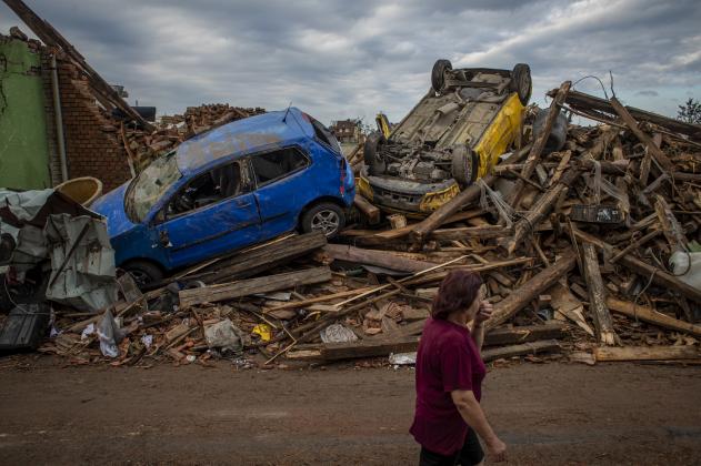 epa09300189 A woman walks past damaged cars after a tornado hit in Mikulcice, Czech Republic, 25 June 2021. A rare tornado on 24 June evening swept through the region of South Moravia, in south-eastern Czech Republic, leaving thousands of houses destroyed