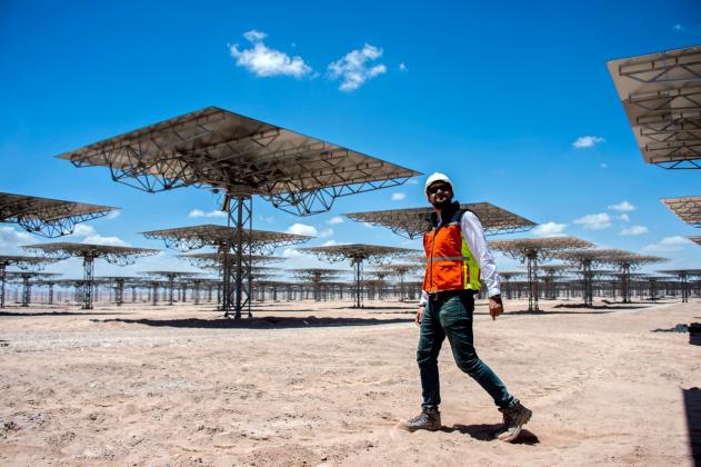 A worker walks near solar panels at Cerro Dominador, the first thermosolar power plant in Latin America, in Antofagasta, Chile, on February 26, 2019. Cerro Dominador is the symbol of the ambitious energetic transition launched by Chile, which aims at havi