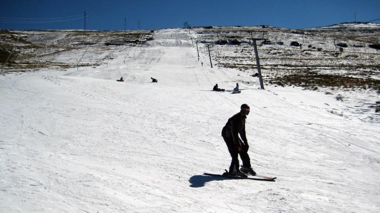 TO GO WITH AFP STORY by Fran Blandy : 'Africa's biggest ski resort taking shape in tiny Lesotho'
People ski 21 June 2007 on a piste of the Afri-Ski resort in the Mahlasela Valley, Lesotho. The glare of the afternoon sun and snow guns lining the piste indi