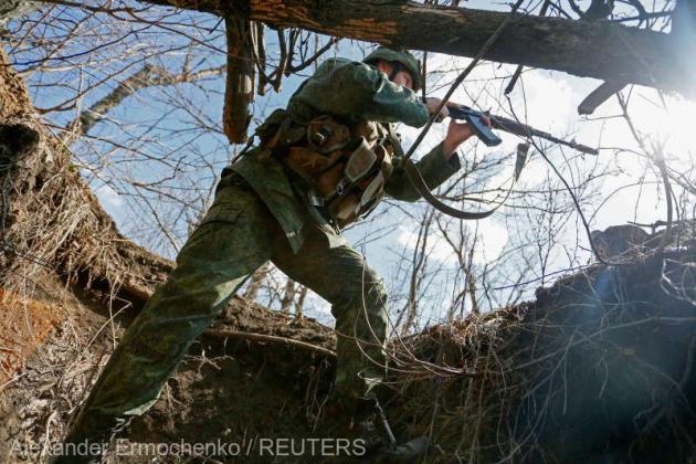 A militant of the self-proclaimed Donetsk People's Republic (DNR) points a weapon at fighting positions on the line of separation from the Ukrainian armed forces south of the rebel-controlled city of Donetsk, Ukraine April 2, 2021. REUTERS/Alexander Ermoc