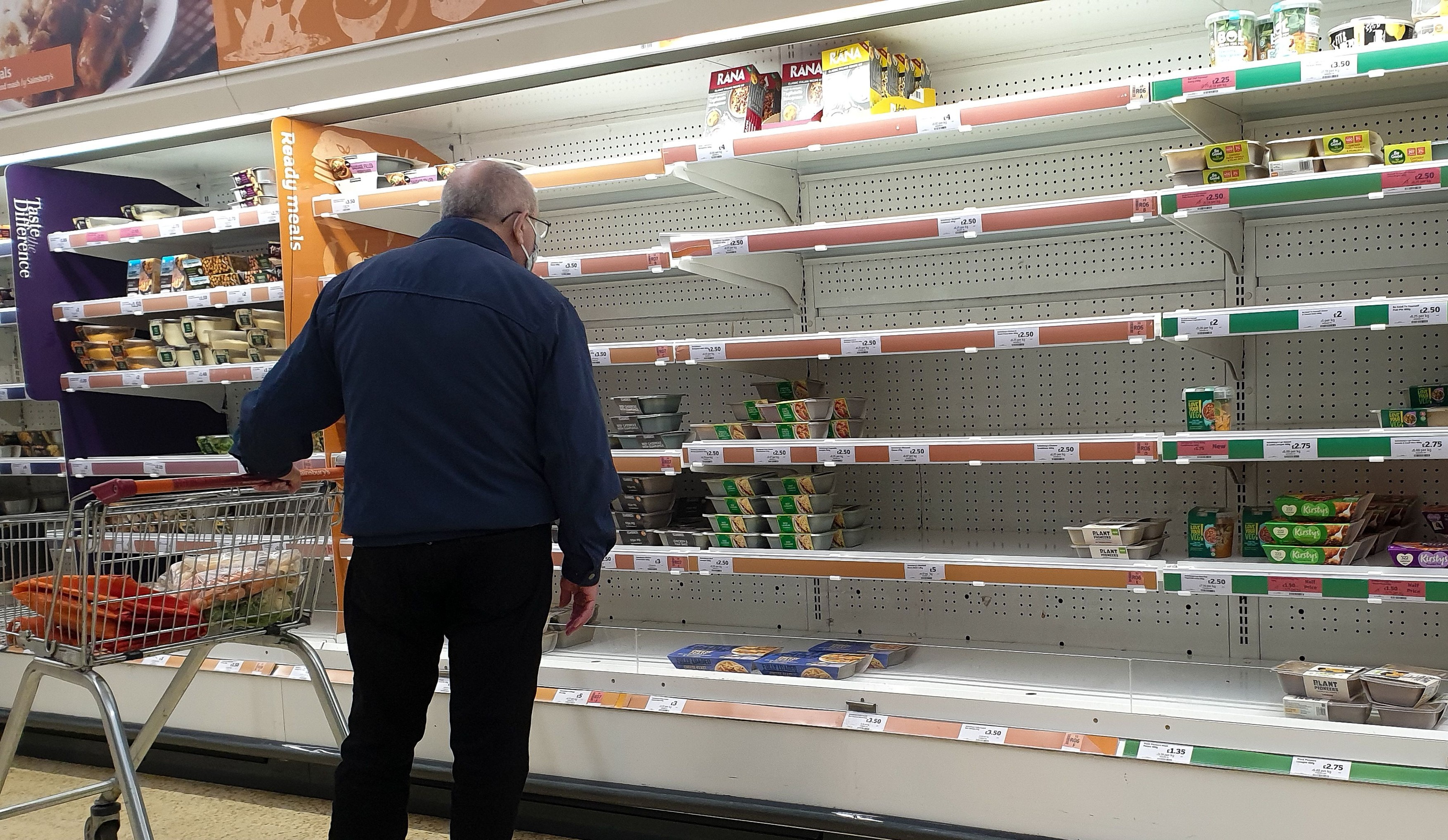 A shopper looks at nearly empty shelves of pre-cooked meat products in Sainsbury's, north London just after 9am. The Government and retailers warn that food and fuel shortages could continue until Christmas due to labour shortages following Brexit.
Short